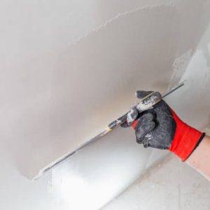 Leveling the walls with white putty – the hands of a master with a spatula Leveling the walls with white putty - the hands of a master with a spatula
